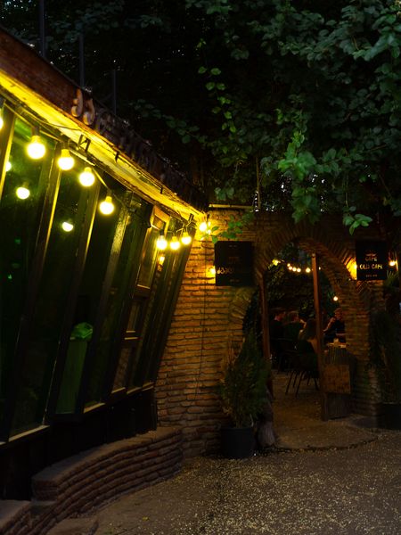 Photo de la devanture d'un bar éclairé, de nuit