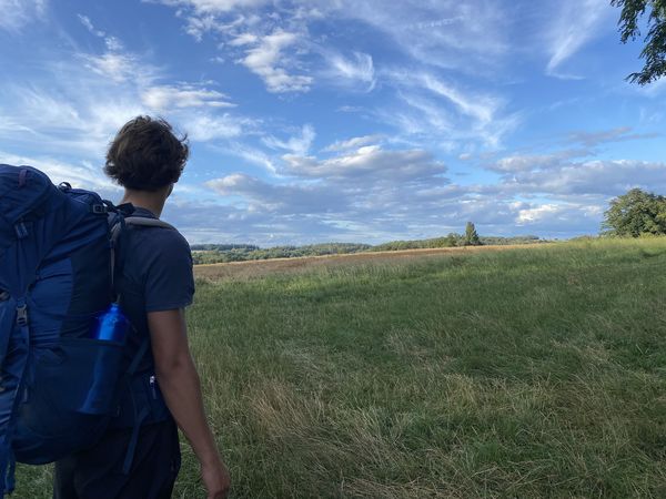 Un homme portant un grand sac à dos devant un paysage